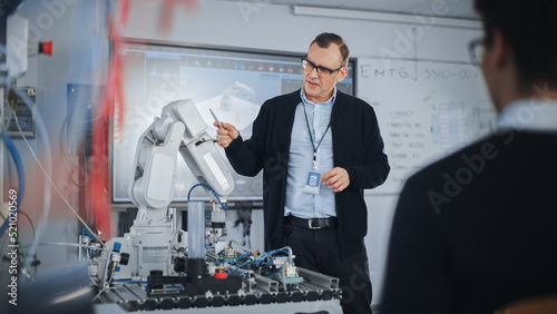 Male Teacher Talking with Students at University Robotics Class at University. Bionic Claw is Moving Under Supervision of the Lector. Computer Science Education and Learning Concept.