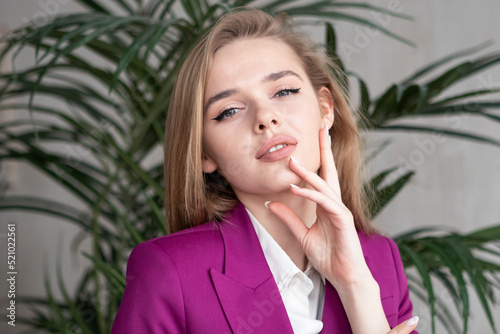 portrait of a young girl with long blonde hair in a purple suit