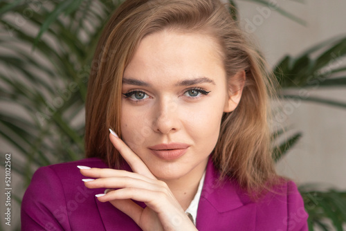 portrait of a young girl with long blonde hair in a purple suit