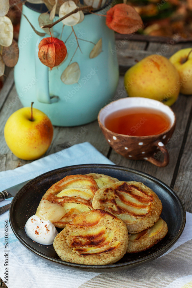 Whole wheat apple pancakes served with tea in the garden. Rustic style.
