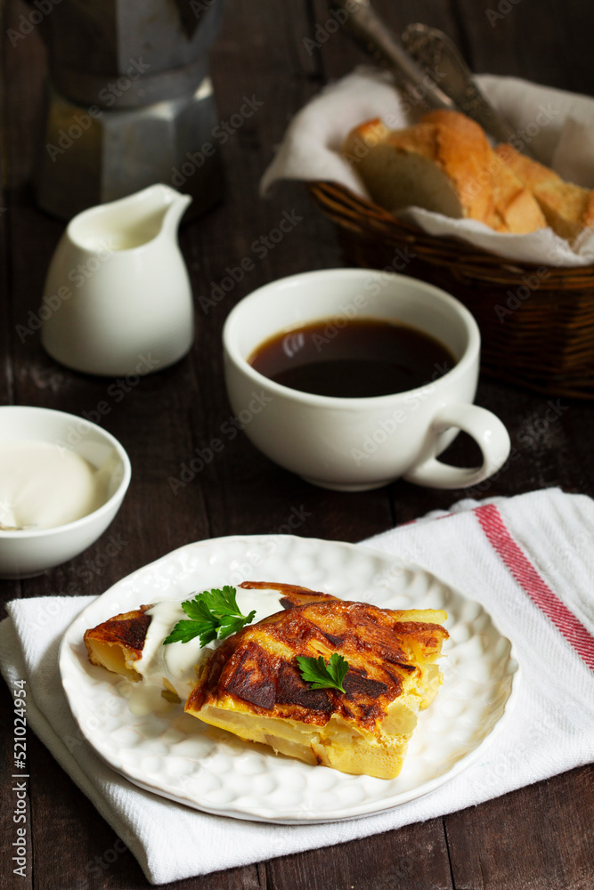Traditional Spanish or Italian omelet with potatoes, served with coffee. Rustic style.