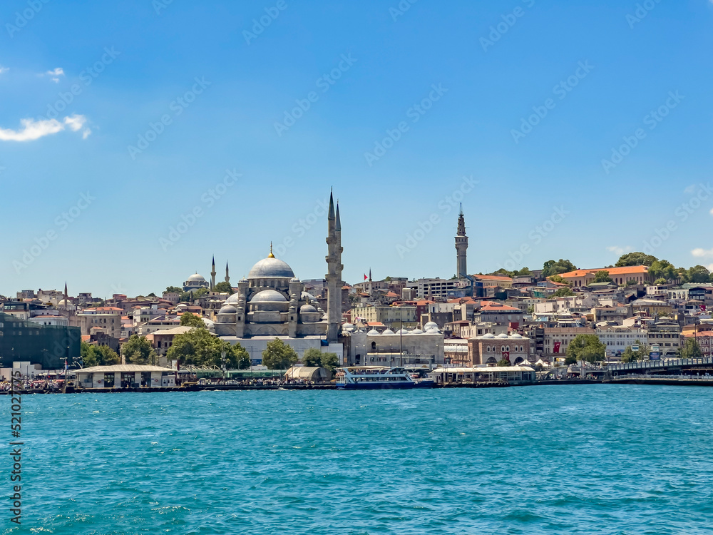 Eminonu - Sirkeci district of Istanbul on a sunny day with Yeni Cami (New Mosque) and the Istanbul University meteorology tower in background. Beautiful travel destination postcard, poster banner