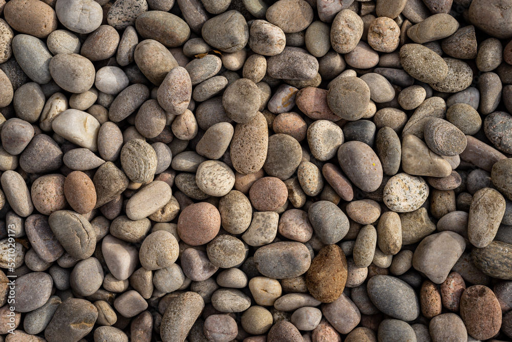 Abstract background of round natural irregular rough rugged brown and beige pebble stones. Abstract background of round natural irregular rough rugged brown and beige pebble stones.