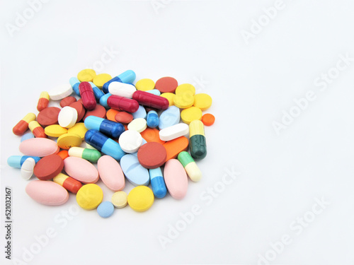  Different colored drugs and pills on the white laboratory table. Creative healthcare of medicine concept. Close the capsule stack. Flat laying.           