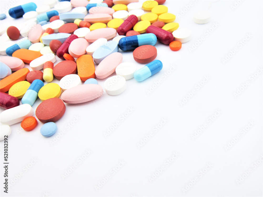 Different colored drugs and pills on the white laboratory table. Creative healthcare of medicine concept. Close the capsule stack. Flat laying. Different colored drugs and pills on the white laboratory table. Creative healthcare of medicine concept. Close the capsule stack. Flat laying.
