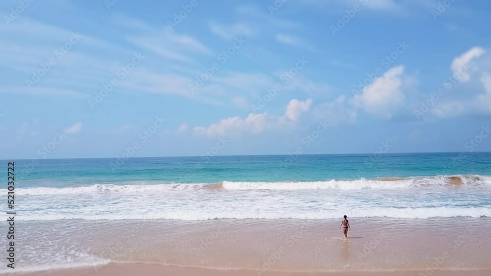 Asian woman feet walking barefoot beach at endless ocean seaside leaving footprints in sand. Female tourist summer vacation woman hand touching water waves splashing tourist. Active lifestyle, Aerial. Asian woman feet walking barefoot beach at endless ocean seaside leaving footprints in sand. Female tourist summer vacation woman hand touching water waves splashing tourist. Active lifestyle, Aerial.