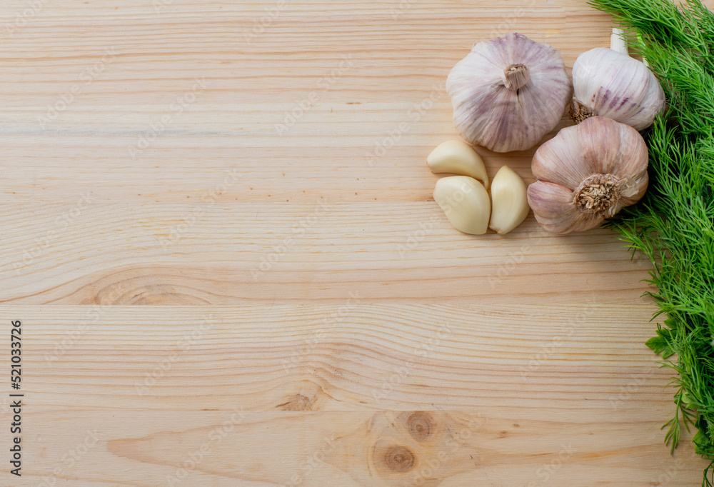 Garlic and herbs on wooden background. Top view, copy space. Garlic and herbs on wooden background. Top view, copy space.