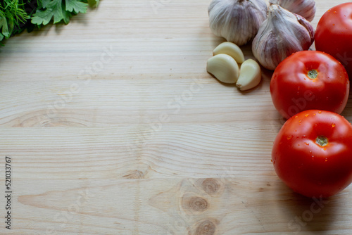 Cooking fresh ingredients background. Organic tomatoes  garlic and herbs on wooden background  top view  copy space.