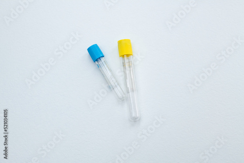 Two vacuum tubes for collection and blood samples with sodium citrate in blue gloves for laboratory. On white background