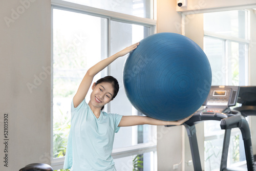 Beautiful and shapely Asian woman working out in the gym, Play exercise machine treadmill, Dumbbell, stretching, Hanging bar, Barbell, Cardio, Stretch, Woman warming up in the gym, Jump rope. photo