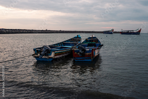 Fishing boats docked in the harbor during the sunset and blue hour