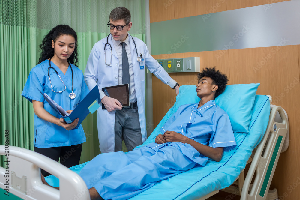 Doctor Visiting man Patient On Ward. Hospitalized man lying in bed while doctor checking his. physician examining male patient in hospital room. Doctor Visiting man Patient On Ward. Hospitalized man lying in bed while doctor checking his. physician examining male patient in hospital room.