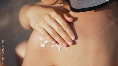 Woman applying sunscreen to her shoulders