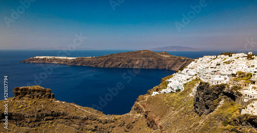 top panoramic shot drone of village of thira and oia in santorini island, greece. with coastline and focus on the cliff