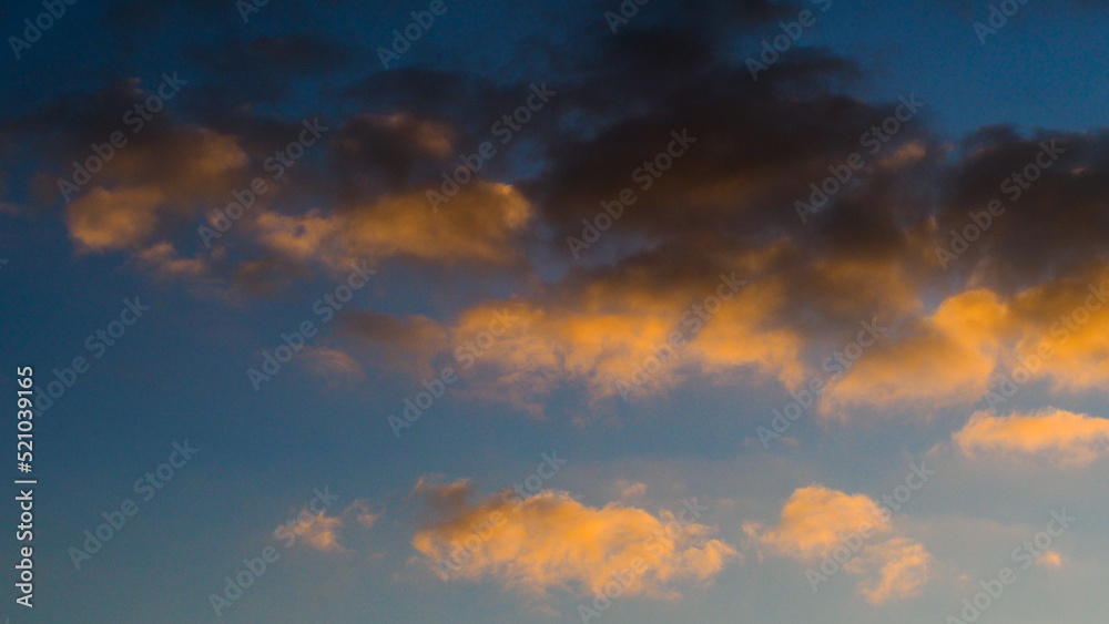 Ciel orangé sous des cumulus, pendant le crépuscule