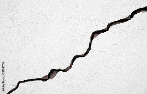 Long deep crack on the damaged wall as texture or background photo