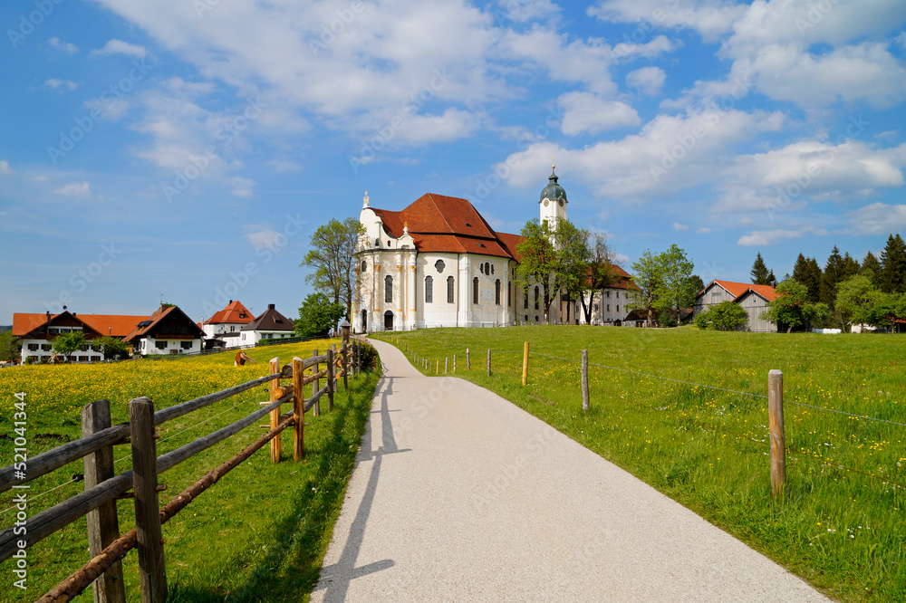 The Pilgrimage Church of Wies (German: Wieskirche) is an oval rococo church in the Bavarian Alps on a sunny day in May (Steingaden, Weilheim-Schongau district, Bavaria, Germany) The Pilgrimage Church of Wies (German: Wieskirche) is an oval rococo church in the Bavarian Alps on a sunny day in May (Steingaden, Weilheim-Schongau district, Bavaria, Germany)
