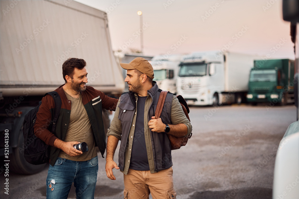 Fototapeta premium Happy truck drivers talk while greeting on parking lot before the ride.