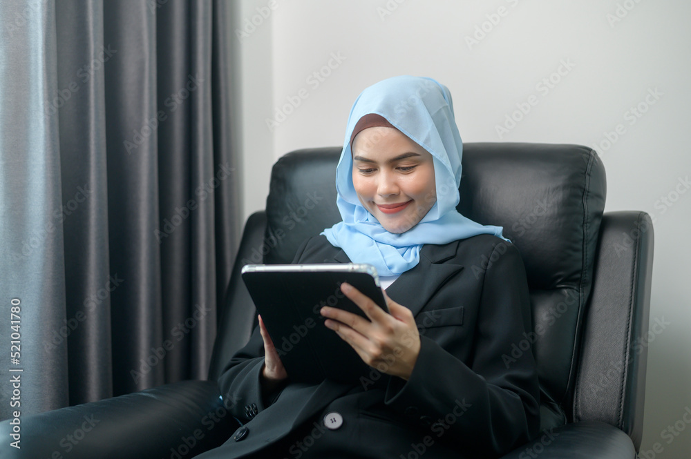 Young muslim business woman using tablet in modern office