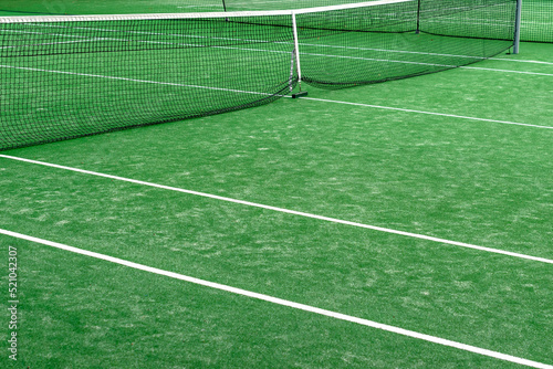 Side view of empty grass tennis court.