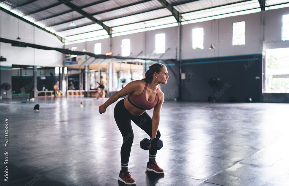 Strong woman in sportswear have weightlifting practice training in gym studio,Caucaisan female with dumbbell exercising during workout for physical recreation - concept of endurance and pursuit effort