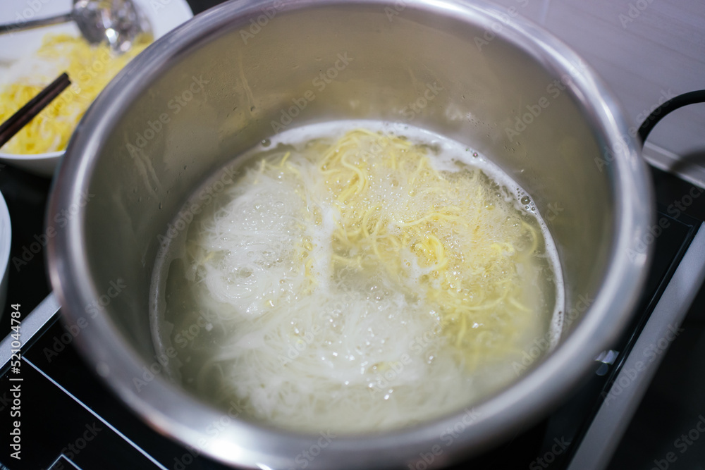 Close up o the boiling water noodle cooking in the pot Close up o the boiling water noodle cooking in the pot