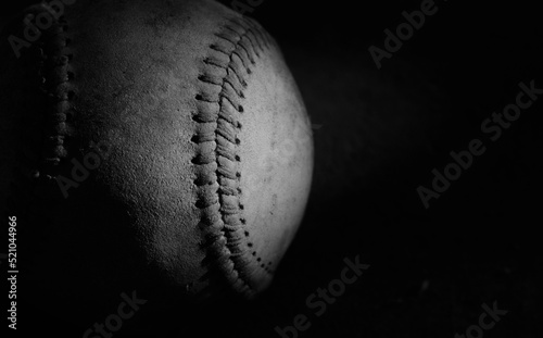 Photography Sports recreation league background with old used baseball close up on black background