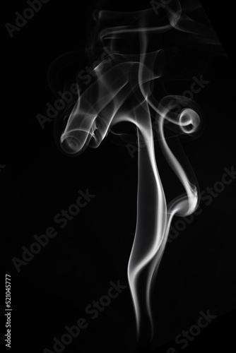 A single white smoke burn from incense, shot in studio with dark black background, for design and religion concept