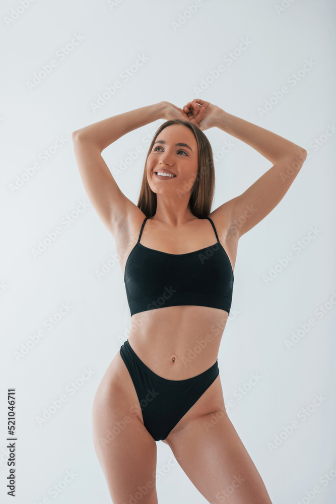 Beautiful female with brown hair. Woman in underwear with slim body type is posing in the studio Beautiful female with brown hair. Woman in underwear with slim body type is posing in the studio