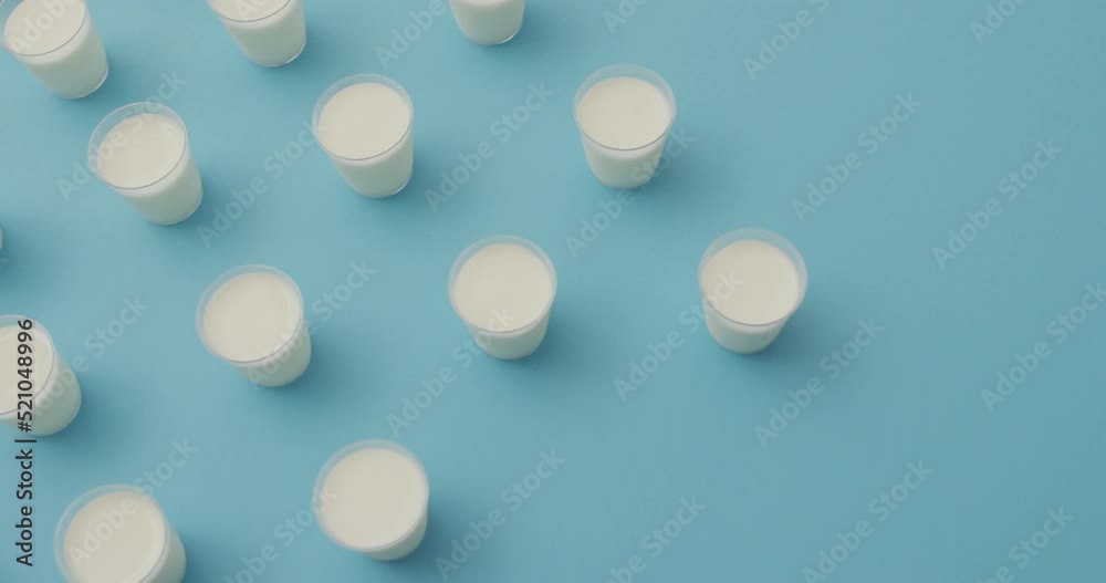 Video of row of glasses of milk on blue background Video of row of glasses of milk on blue background
