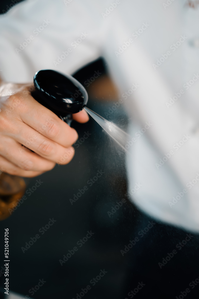 Professional restaurant kitchen, close-up: male chef splashes mushrooms with oil. Cooking delicious food in restaurant.