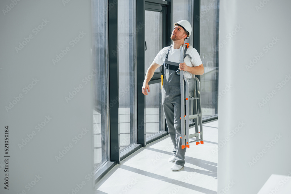 With leader near windows. Repairman is working indoors in the modern room With leader near windows. Repairman is working indoors in the modern room