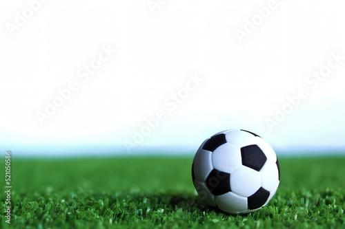 Selective focus image of football  soccer ball on green soccer field isolated on white background