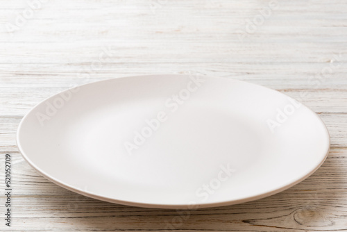 Perspective view of empty light plate on wooden background. Empty space for your design