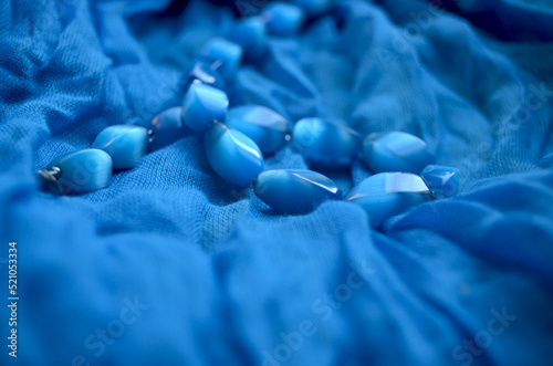 Blue beads from a natural stone on a female scarf.