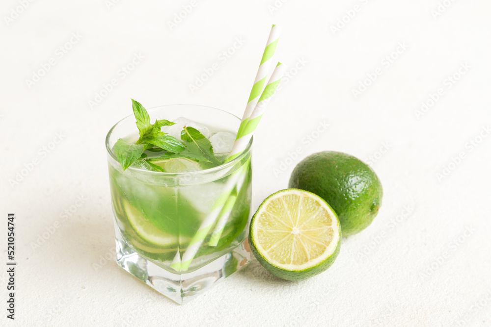 Fototapeta premium Mojito cocktail. Refreshing mojito cocktail with lime, lemon and mint in a tall glass with a stick