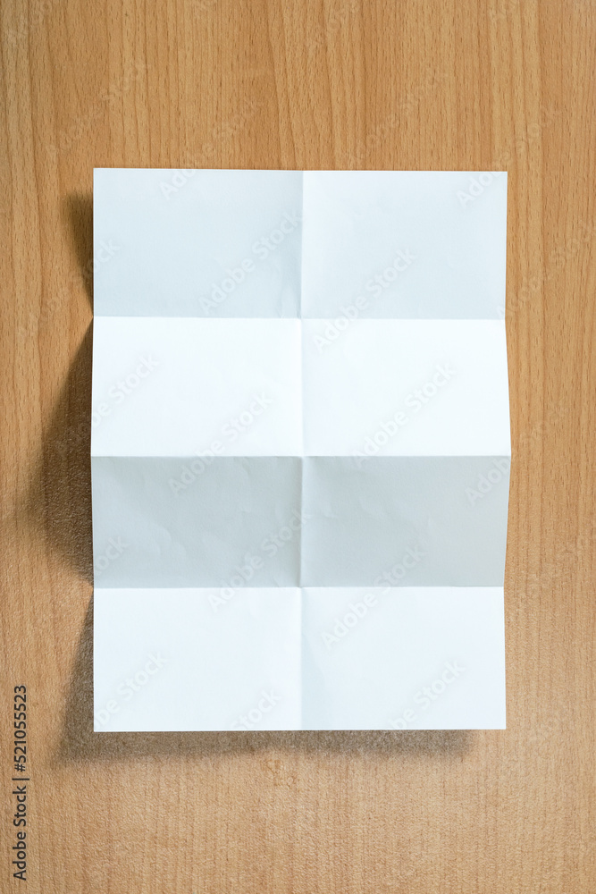 White paper with folds on a wooden floor. White paper with folds on a wooden floor.