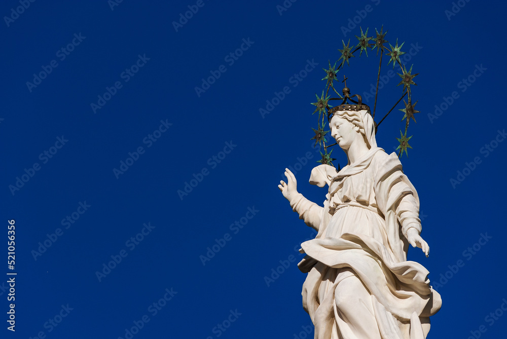 Statue of Virgin Mary of the Stars at the top of an ancient column in the historic center of Lucca, erected in 1687 (with blue sky and copy space)