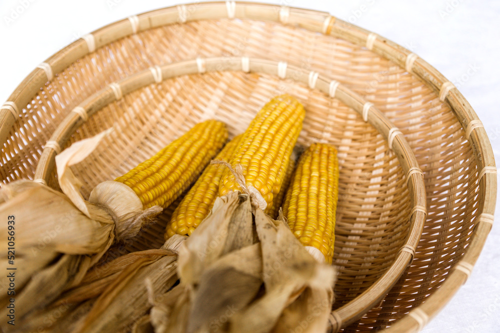 Yellow dry corn in a wicker basket as a decor on the table Yellow dry corn in a wicker basket as a decor on the table