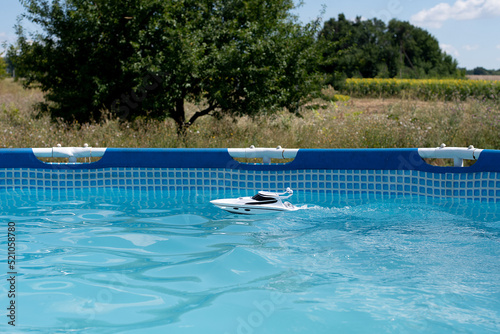 children's toy boat in the pool. water games in summer in sunny weather