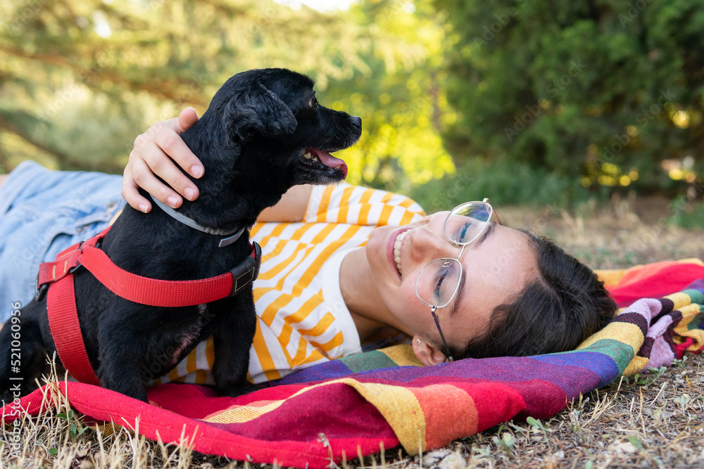 Happy young woman with dog on colorful blanket Happy young woman with dog on colorful blanket