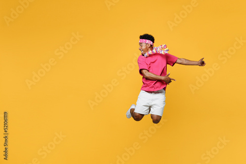 Young happy fun expressive man 20s he wear pink t-shirt near hotel pool jump high play guitar look aside on workspace area mock up isolated on plain yellow background Summer vacation sea rest concept © ViDi Studio