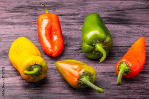 red yellow and green peppers on a wooden table