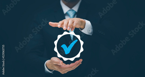 Quality assurance of business services, Businessman Hand shows the sign of the top service Quality assurance in Black background , Guarantee, Standards, ISO certification and standardization concept.