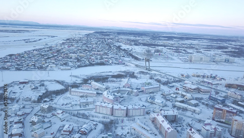 Top view of town on background of horizon in winter. Clip. Beautiful view of city by lake with winter landscape on horizon. Snow-covered town with lakes on cloudy winter day