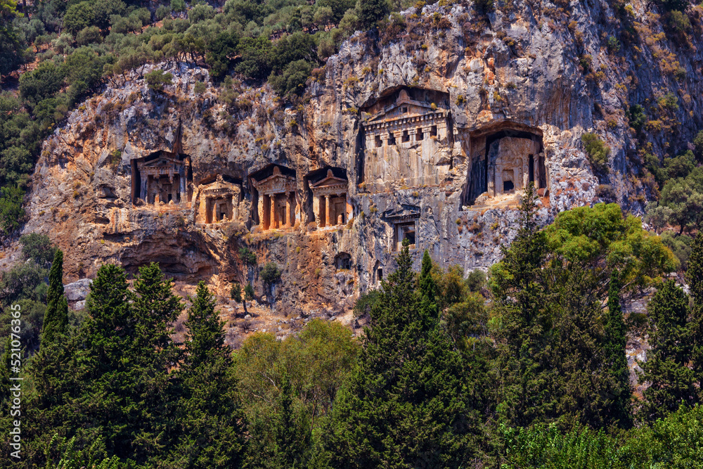 Famous rock-cut Lycian grave tombs of kings in carved caves in the cliffs of ancient Caunos (Kaunos) town, a UNESCO world heritage site at Dalyan, Mugla, Turkey.