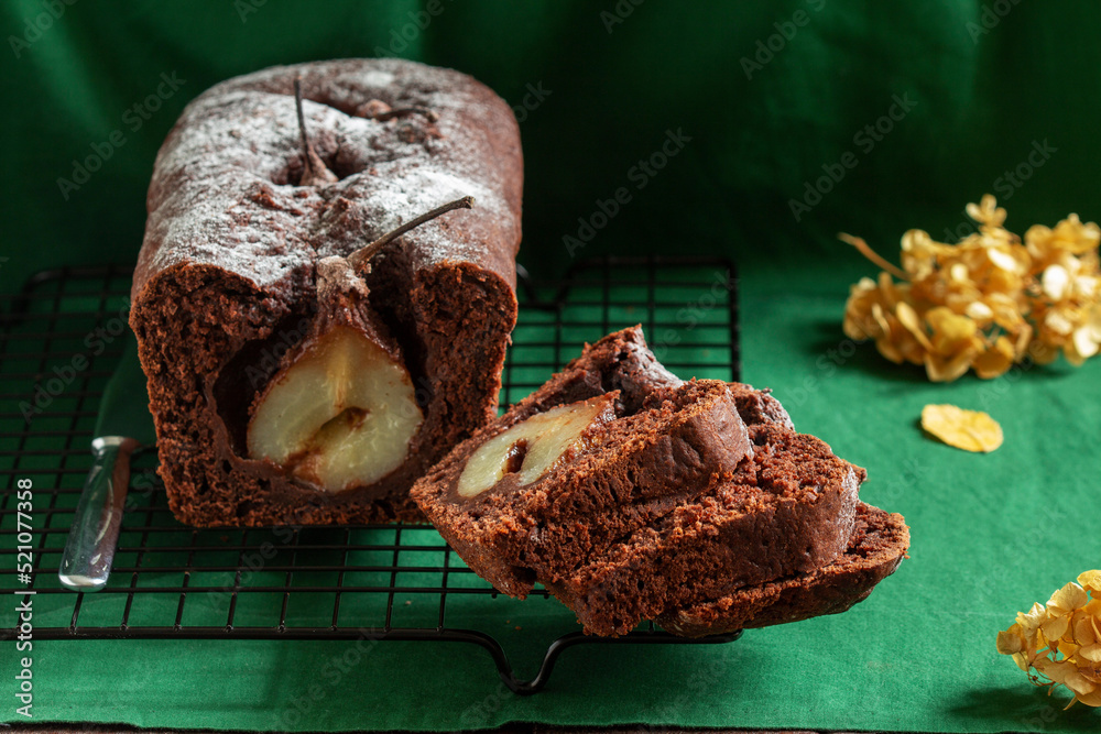Chocolate pear cake on a green background. Rustic style.