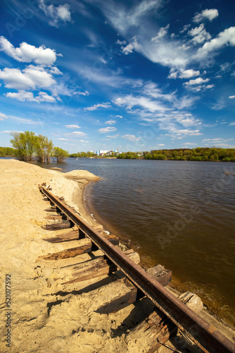 Landscape with the shore of Oka river at the mouth of Moscow river, sky, clouds and old railroad, Kolomna city, Moscow region, Russia