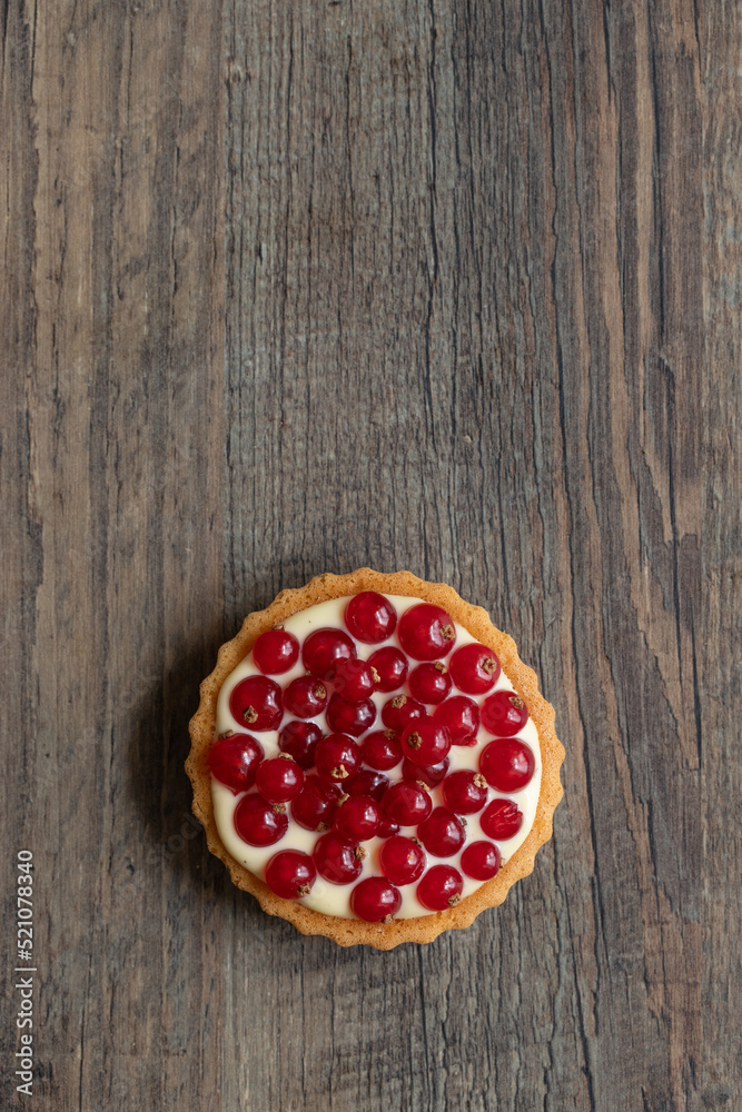rote Johannisbeeren und Pudding in Törtchen auf Tisch aus Holz rote Johannisbeeren und Pudding in Törtchen auf Tisch aus Holz