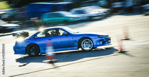 Stunt drivers race and drift their modified Japanese cars on a sunny track day in Somerset, England